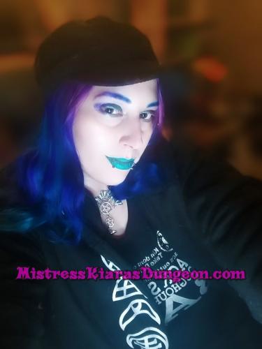 gothic femdom queen Mistress Domina Kiara smirking